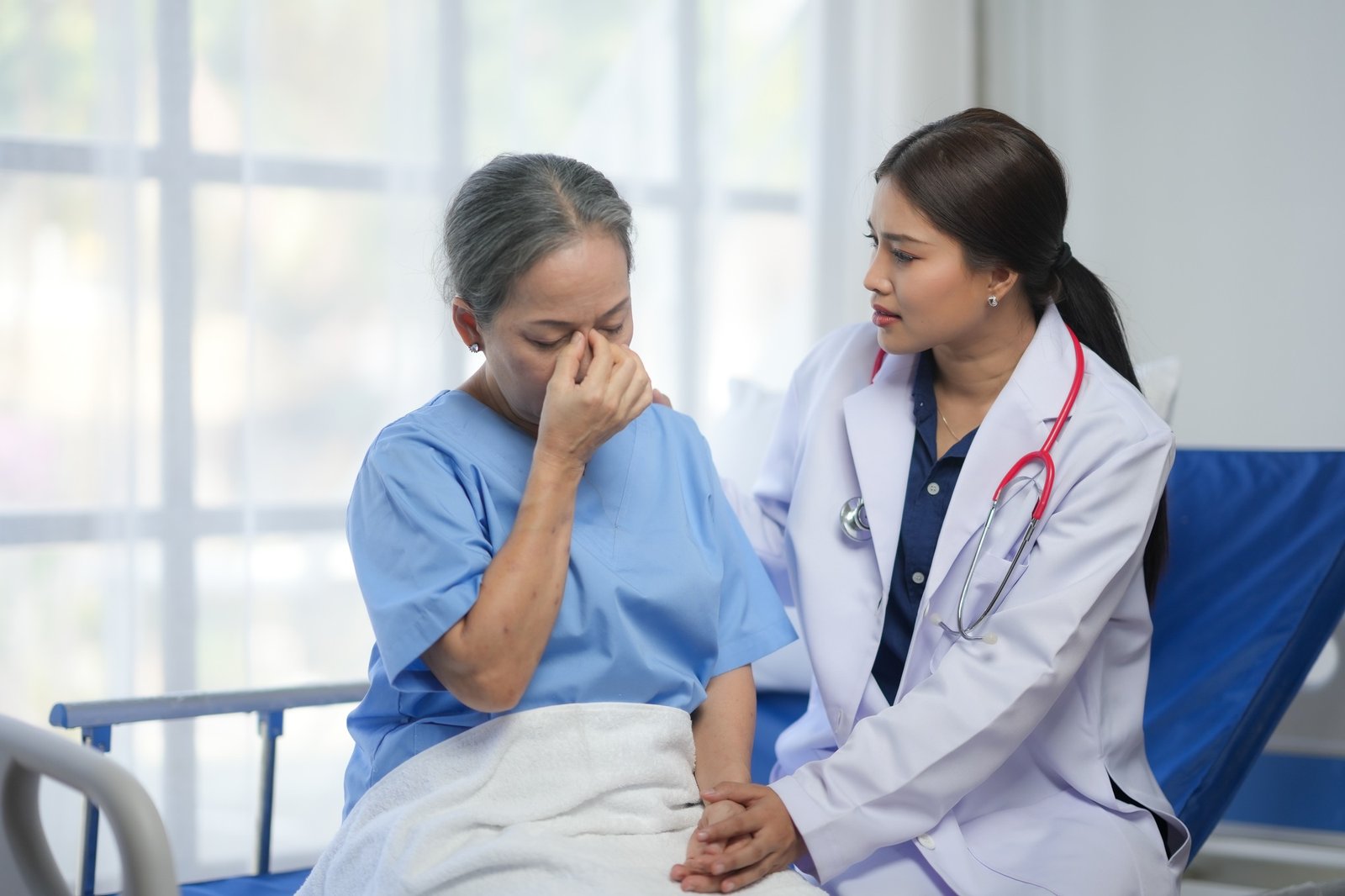 A healthcare professional comforts a distressed elderly patient