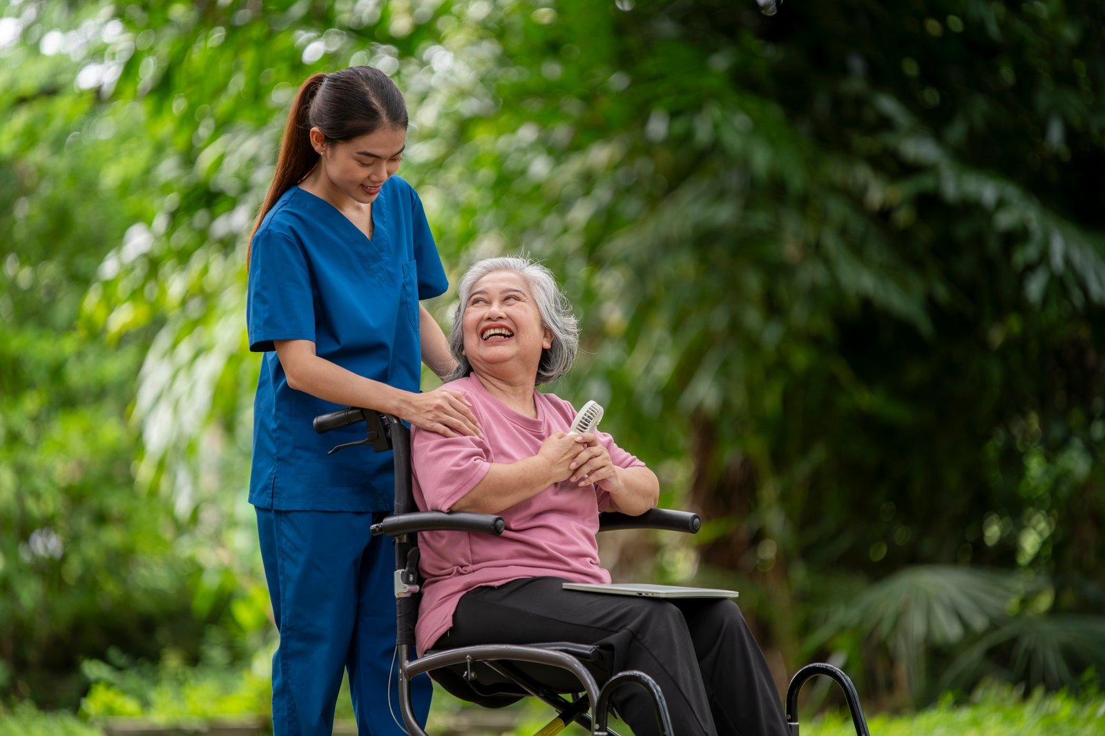 Healthcare or physical therapy nurse is helping elderly woman in performing a stretching or rehabili