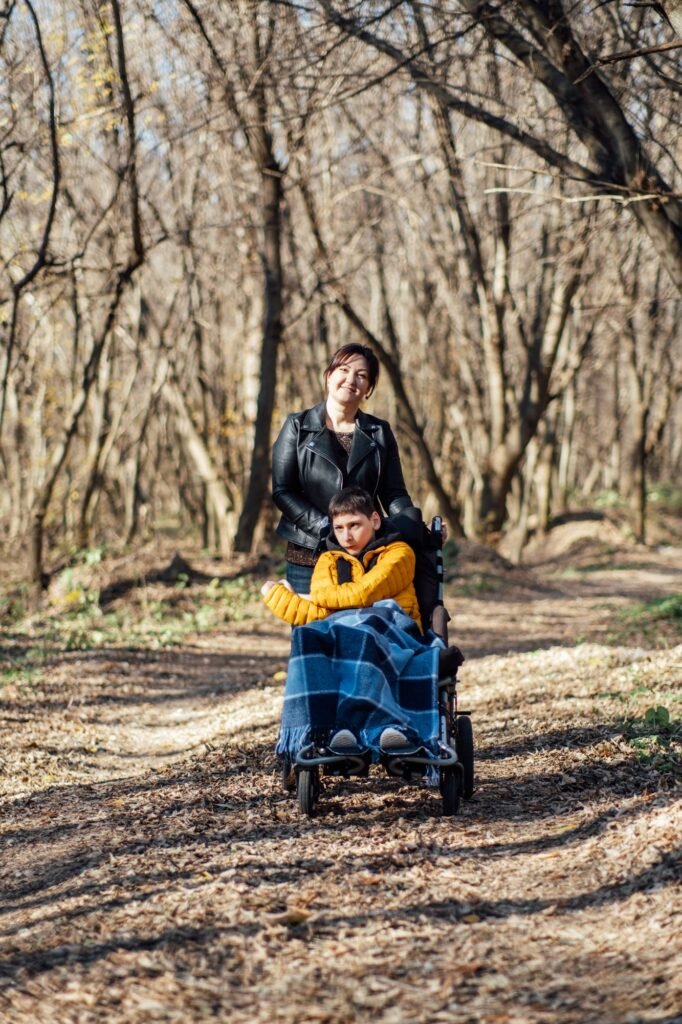 Mother and child with special needs enjoying nature walk in forest, accessibility in outdoor